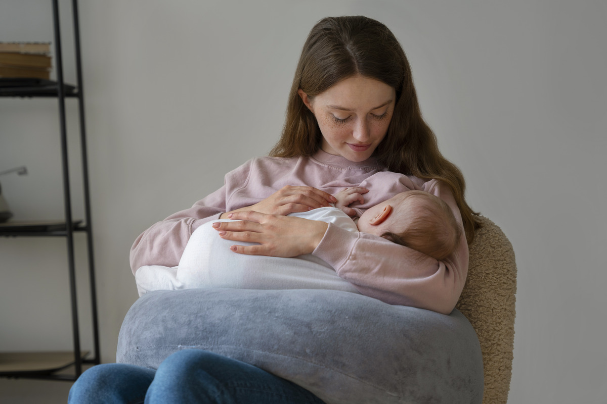 Mother breastfeeding her baby with a breastfeeding pillow, Breastfeeding Consultant in Pune